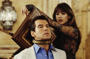 James Bond is strapped to an ornate wooden chair. A metal collar round his neck attaches him to the chair, and a beautiful dark-haired woman is turning handles attached to the back of the chair — it's a very tasteful instrument of torture.