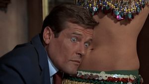 James Bond is resting his head against the bare belly of a woman, whose head we can't see. He looks very surprised.