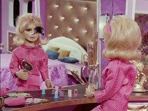 Lady Penelope (a marionette) is in her lavishly pink bedroom staring at her reflection in the mirror. There is a bullet hole in the mirror where her left eye would be.